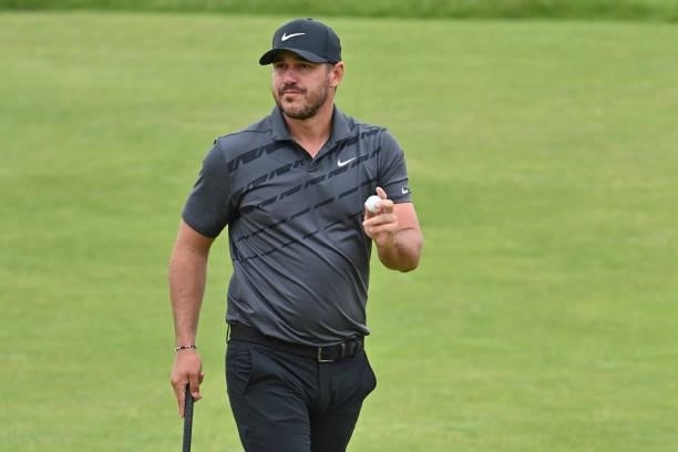Golfer Brooks Koepka reacts after making his putt on the 16th green during his first round on day one of The 149th British Open Golf Championship at...