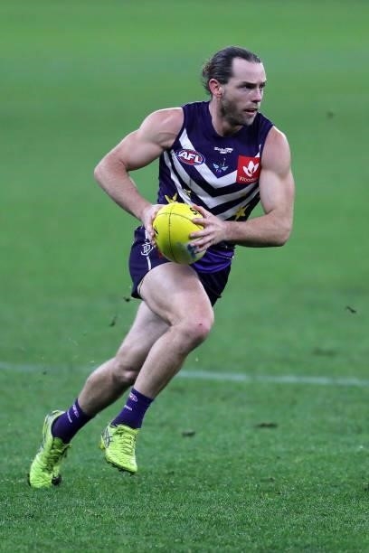 Travis Colyer of the Dockers runs with the ball during the 2021 AFL Round 18 match between the Fremantle Dockers and the Geelong Cats at Optus...
