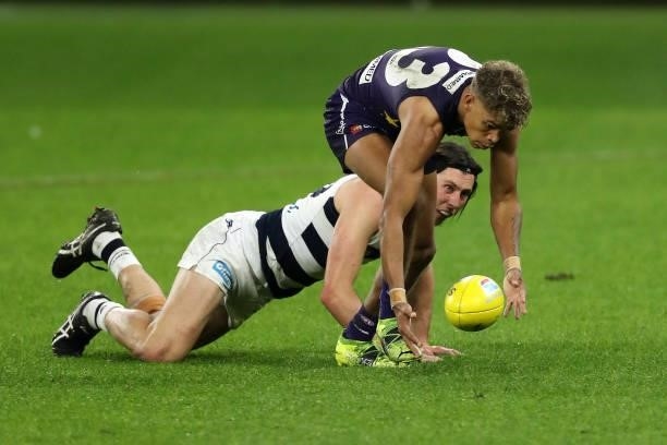 Jack Henry of the Cats looks on as Liam Henry of the Dockers gathers the ball during the 2021 AFL Round 18 match between the Fremantle Dockers and...