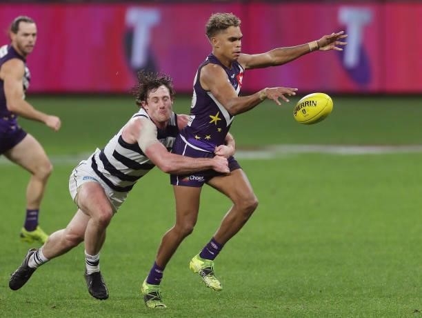 Liam Henry of the Dockers is tackled by Jed Bews of the Cats during the 2021 AFL Round 18 match between the Fremantle Dockers and the Geelong Cats at...