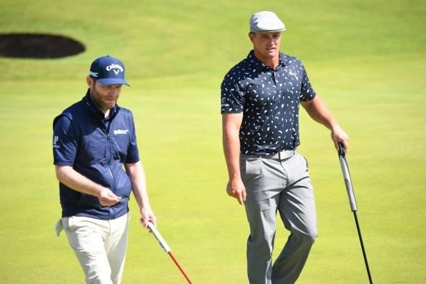 South Africa's Branden Grace and US golfer Bryson DeChambeau arrive on the 6th green during their first rounds on day one of The 149th British Open...