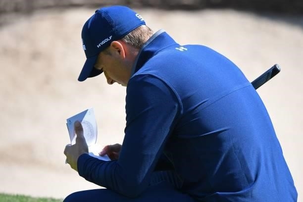 Golfer Jordan Spieth studies his course map on the 6th green during his first round on day one of The 149th British Open Golf Championship at Royal...