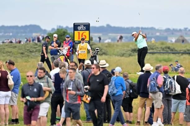 Specators walk past as England's Jonathan Thomson plays from the 16th tee during his first round on day one of The 149th British Open Golf...