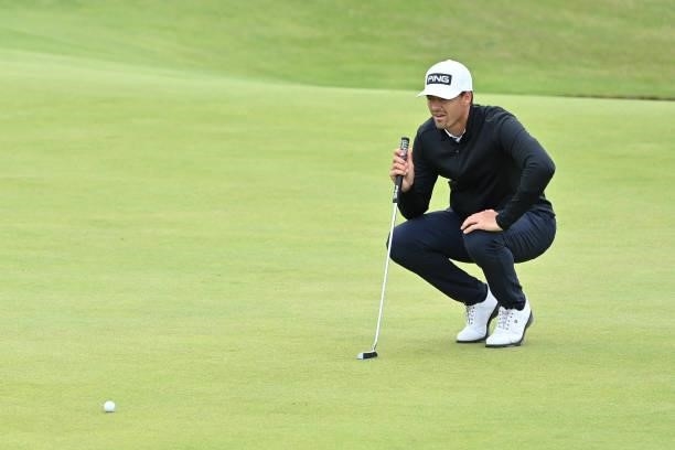France's Victor Perez lines up his putt on the 16th green during his first round on day one of The 149th British Open Golf Championship at Royal St...