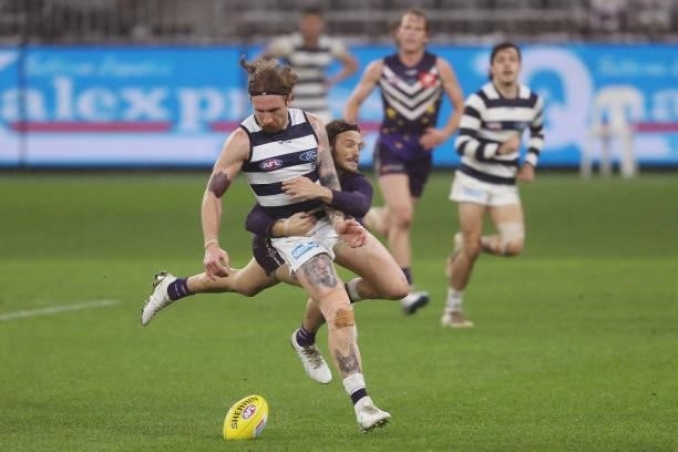 Zach Tuohy of the Cats is tackled by James Aish of the Dockers during the 2021 AFL Round 18 match between the Fremantle Dockers and the Geelong Cats...