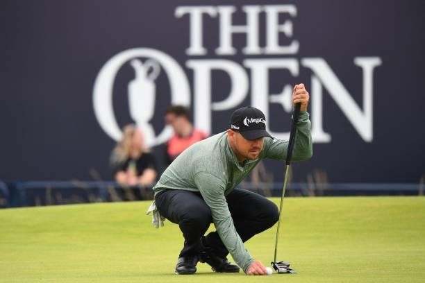 Golfer Brian Harman places his ball on the 18th green during his first round on day one of The 149th British Open Golf Championship at Royal St...