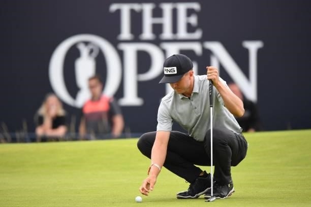 Canada's Mackenzie Hughes places his ball on the 18th green during his first round on day one of The 149th British Open Golf Championship at Royal St...