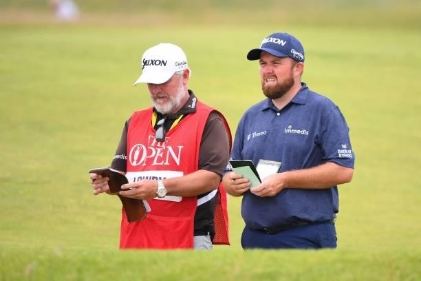 Ireland's Shane Lowry and caddie Brian Martin check their course notes on the 18th fairway during his first round on day one of The 149th British...