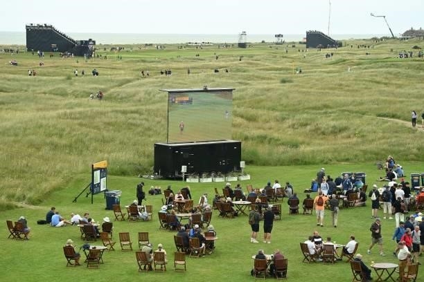 Spectators watch play on a big screen by the 12th hole on the opening day of The 149th British Open Golf Championship at Royal St George's, Sandwich...