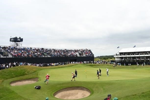 Ireland's Shane Lowry and his partners leave the 16th green during his first round on day one of The 149th British Open Golf Championship at Royal St...