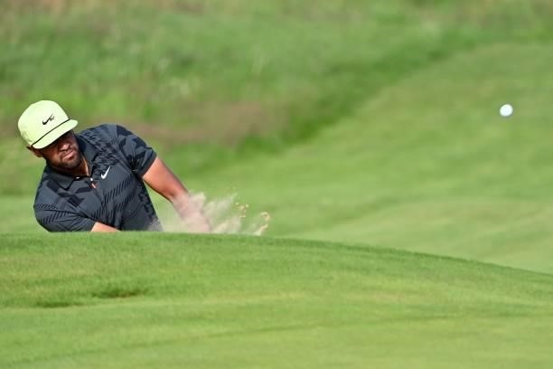 Golfer Tony Finau chips out of a green-side bunker on the 18th hole during his first round on day one of The 149th British Open Golf Championship at...