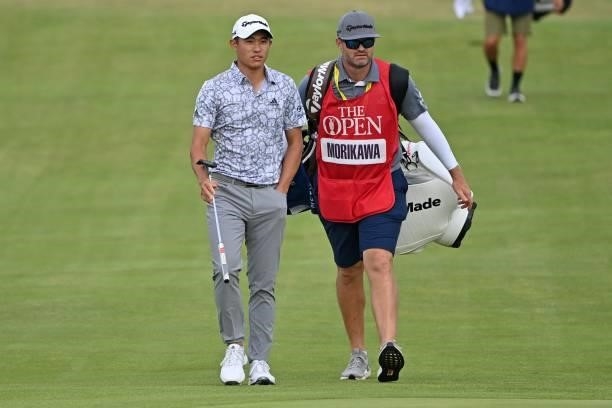 Golfer Collin Morikawa and his caddie JJ Jakovac walk up the 18th fairway during his first round on day one of The 149th British Open Golf...