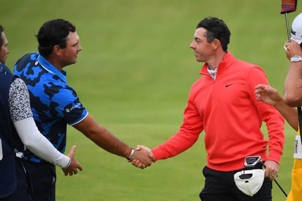 Northern Ireland's Rory McIlroy shakes hands with US golfer Patrick Reed on the 18th green after their first rounds on day one of The 149th British...