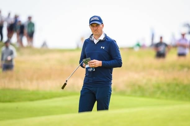 Jordan Spieth checks his yardage book on the ninth hole green during Day One of the 149th The Open Championship at Royal St. Georges Golf Club on...