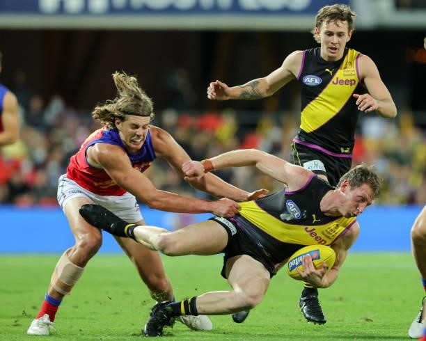 Dylan Grimes is tackled during the 2021 AFL Round 18 match between the Richmond Tigers and the Brisbane Lions at Metricon Stadium on July 16, 2021 in...