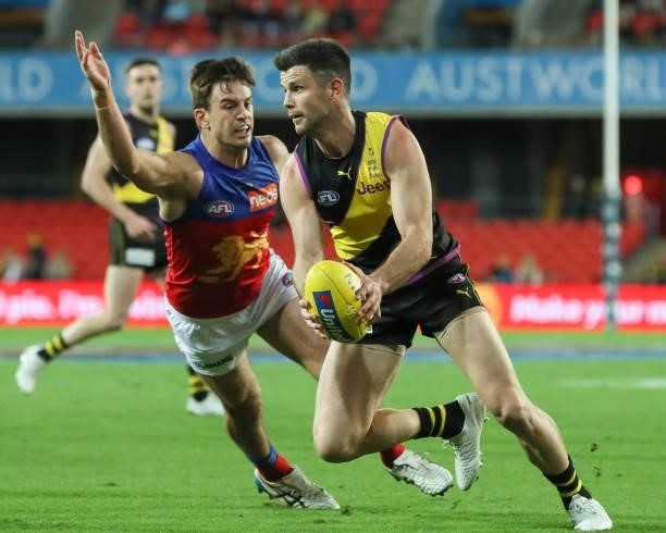 Trent Cotchin evades a tackle during the 2021 AFL Round 18 match between the Richmond Tigers and the Brisbane Lions at Metricon Stadium on July 16,...