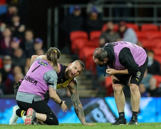 Dustin Martin lays injured on the ground during the 2021 AFL Round 18 match between the Richmond Tigers and the Brisbane Lions at Metricon Stadium on...