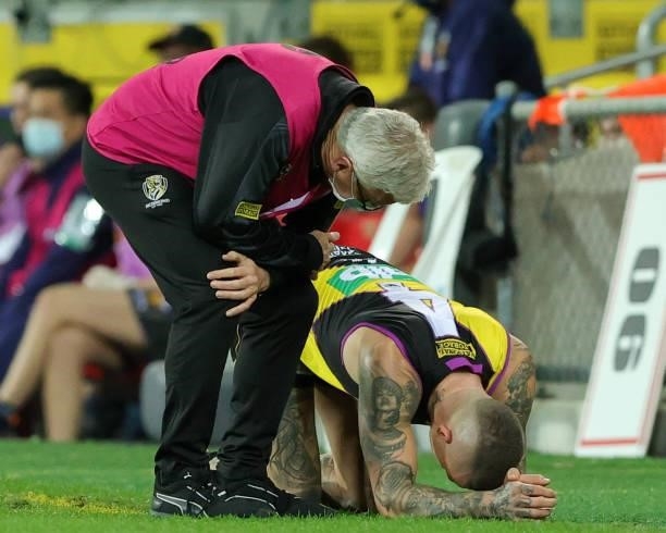 Dustin Martin lays on the ground injured during the 2021 AFL Round 18 match between the Richmond Tigers and the Brisbane Lions at Metricon Stadium on...