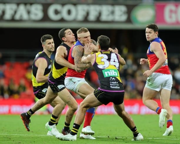 Mitch Robinson is tackled during the 2021 AFL Round 18 match between the Richmond Tigers and the Brisbane Lions at Metricon Stadium on July 16, 2021...