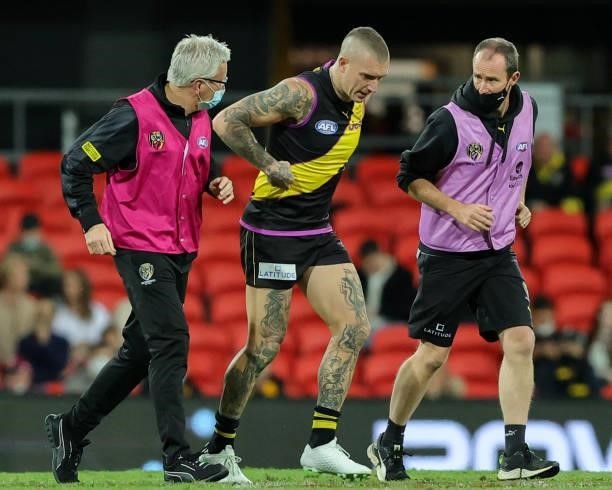 Dustin Martin is helped off the ground after being injured during the 2021 AFL Round 18 match between the Richmond Tigers and the Brisbane Lions at...