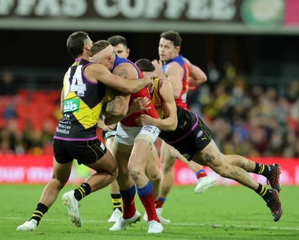 Mitch Robinson is tackled during the 2021 AFL Round 18 match between the Richmond Tigers and the Brisbane Lions at Metricon Stadium on July 16, 2021...