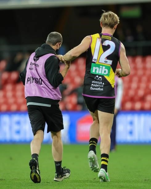 David Astbury limps off injured during the 2021 AFL Round 18 match between the Richmond Tigers and the Brisbane Lions at Metricon Stadium on July 16,...