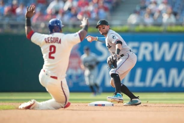 Miguel Rojas of the Miami Marlins turns a double play against Jean Segura of the Philadelphia Phillies in the bottom of the fourth inning during Game...