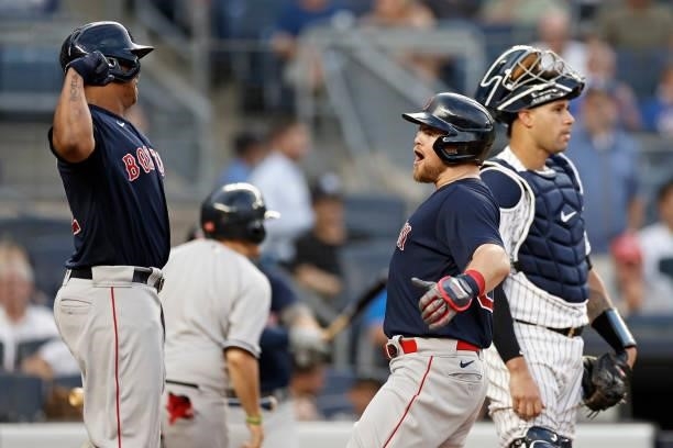Christian Arroyo of the Boston Red Sox celebrates hitting a 2-run home run with Rafael Devers of the Boston Red Sox in front of Gary Sanchez of the...
