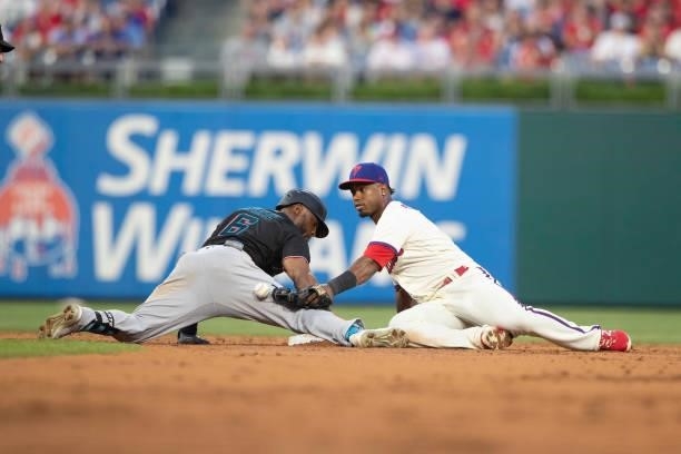 Starling Marte of the Miami Marlins slides into second base safely past the tag of Jean Segura of the Philadelphia Phillies for a double in the top...