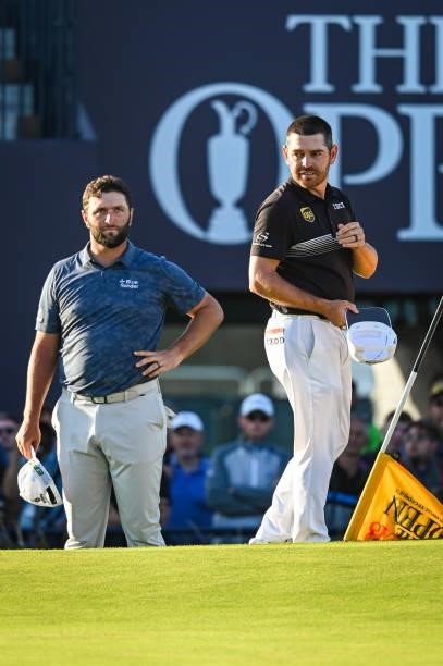 Louis Oosthuizen of South Africa stands with Jon Rahm of Spain after finishing play on the 18th hole green during Day Two of the 149th The Open...
