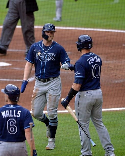 Austin Meadows of the Tampa Bay Rays bumps fists with Mike Zunino after scoring a run in the second inning against the Atlanta Braves at Truist Park...