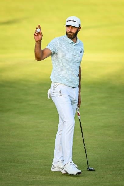 Dustin Johnson waves his ball to fans after making a birdie putt on the 18th hole green during Day Two of the 149th The Open Championship at Royal...