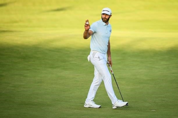 Dustin Johnson waves his ball to fans after making a birdie putt on the 18th hole green during Day Two of the 149th The Open Championship at Royal...