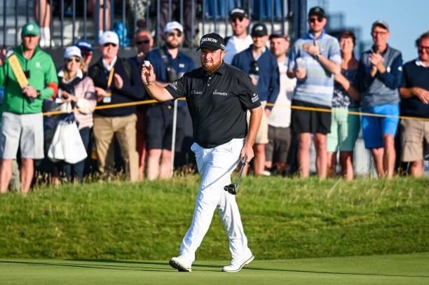 Shane Lowry of Ireland waves his ball to fans after making a birdie putt on the 17th hole green during Day Two of the 149th The Open Championship at...