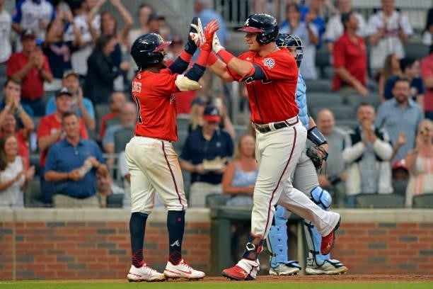 Austin RIley of the Atlanta Braves celebrates with Ozzie Albies after a two-run home run in the fourth inning against the Tampa Bay Rays at Truist...