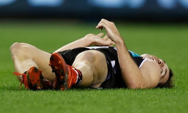 Daniel McKenzie of the Saints lays injured water tackling Mitch Georgiades of the Power during the 2021 AFL Round 18 match between the St Kilda...