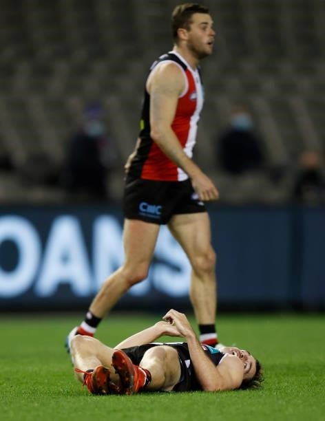 Daniel McKenzie of the Saints lays injured water tackling Mitch Georgiades of the Power during the 2021 AFL Round 18 match between the St Kilda...
