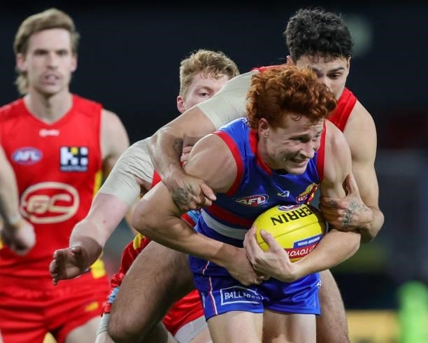 Ed Richards of the Bulldogs is tackled by Izak Rankine of the Suns during the 2021 AFL Round 18 match between the Gold Coast Suns and the Western...