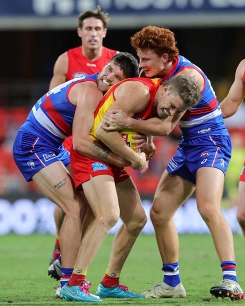 Nick Holman of the Suns is wrapped up in a tackle during the 2021 AFL Round 18 match between the Gold Coast Suns and the Western Bulldogs at Metricon...