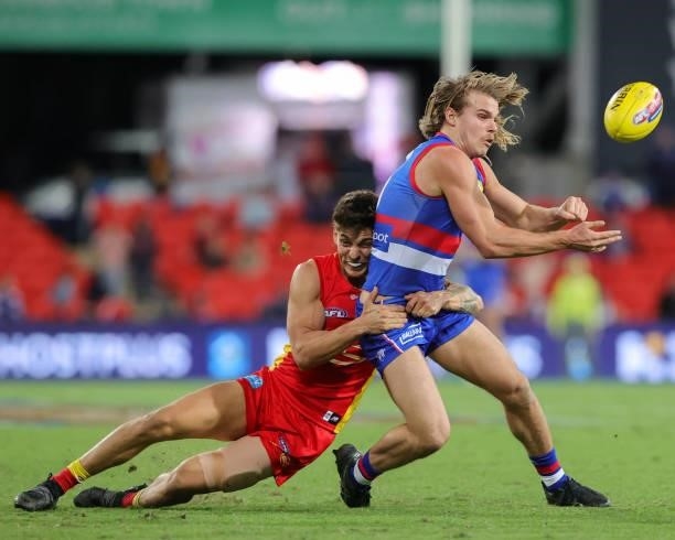 Bailey Smith of the Bulldogs is tackled by Sean Lemmens of the Suns during the 2021 AFL Round 18 match between the Gold Coast Suns and the Western...