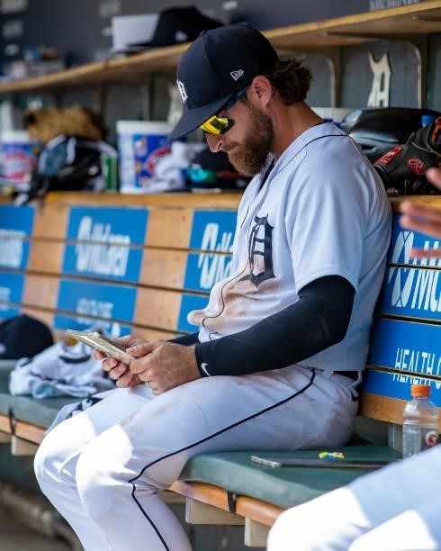 Eric Haase of the Detroit Tigers looks at an iPad on the bench between innings against the Minnesota Twins during game one of a double header at...