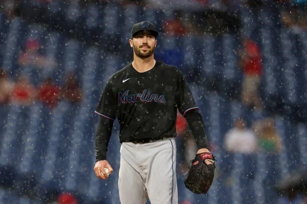 Pitcher John Curtiss of the Miami Marlins looks at the rain as it falls as the ground crew comes out to cover the field during the fifth inning of a...