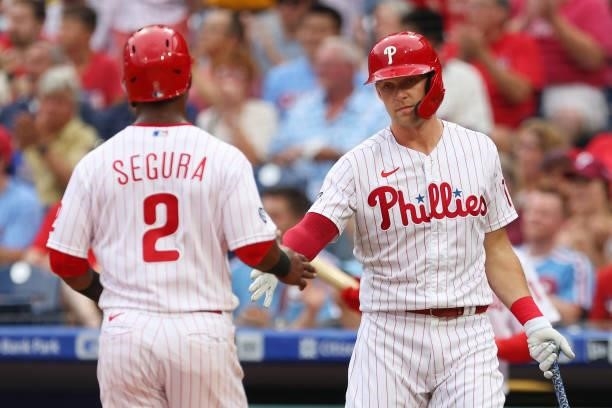 Jean Segura of the Philadelphia Phillies is congratulated by Rhys Hoskins after scoring on a sacrifice fly by Andrew McCutchen during the first...