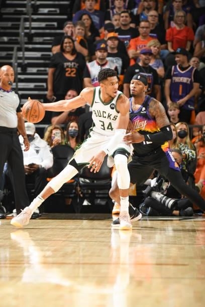Giannis Antetokounmpo of the Milwaukee Bucks handles the ball as Torrey Craig of the Phoenix Suns plays defense during Game Five of the 2021 NBA...