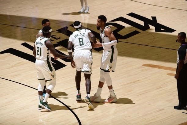 July 17: Jrue Holiday and Giannis Antetokounmpo of the Milwaukee Bucks help up Bobby Portis during Game Five of the 2021 NBA Finals on July 17, 2021...