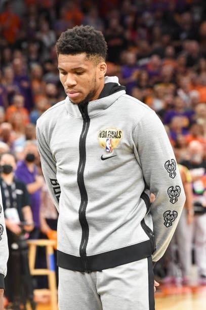 Giannis Antetokounmpo of the Milwaukee Bucks listens to the national anthem before the game against the Phoenix Suns during Game Five of the 2021 NBA...