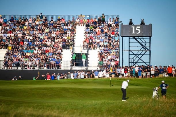 Fans watch as Scottie Scheffler chips a shot to the 15th green during Day Two of the 149th The Open Championship at Royal St. Georges Golf Club on...