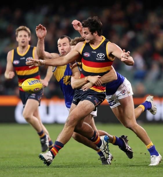 Darcy Fogarty of the Crows under pressure from Brad Sheppard of the Eagles and Shannon Hurn during the 2021 AFL Round 18 match between the Adelaide...