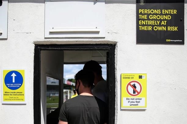 Fans enter through turnstiles with COVID information and signage during the Pre Season Friendly between Harrogate Town and Newcastle United at The...