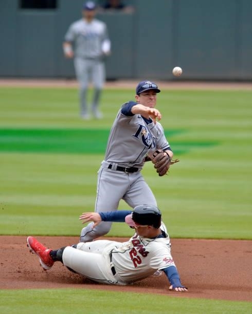 Joey Wendle of the Tampa Bay Rays throws to first base as Joc Pederson of the Atlanta Braves slides into second base in the first inning at Truist...